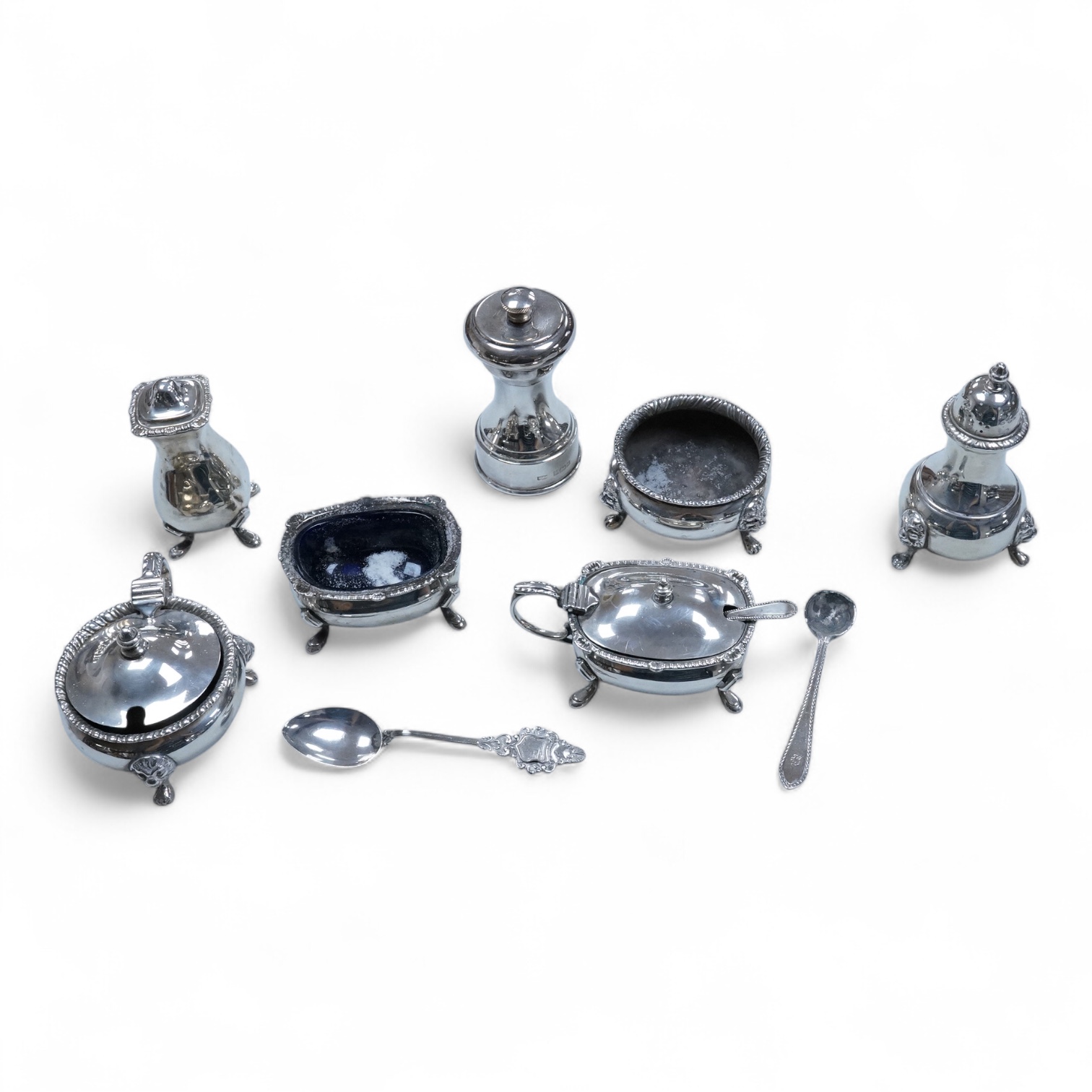 Two George VI silver three piece condiment sets by Walker & Hall, London, 1936/7, together with a modern silver mounted pepper mill by Mappin & Webb and two plated spoons.